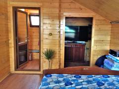 Interior rustic al unei case din lemn finisata cu lambriu de pin lacuit